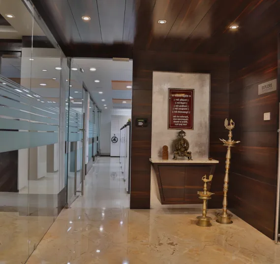 Glass office entrance beside a ceremonial brass lamp